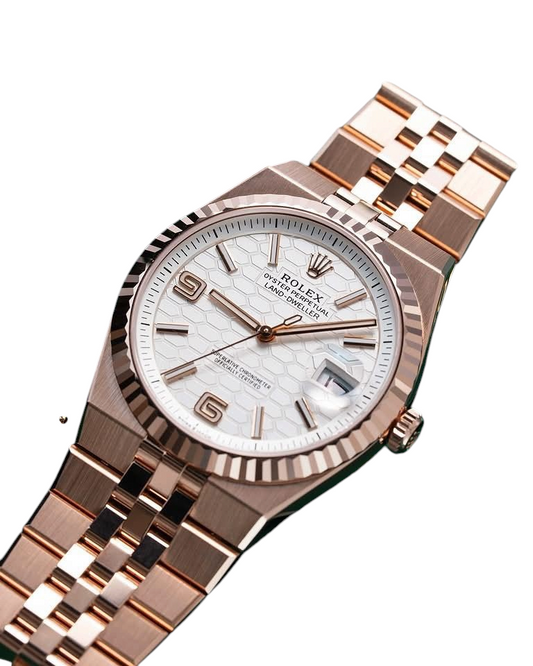 ACCHA TIME rose gold watch featuring a white honeycomb dial, fluted bezel, and Jubilee bracelet on a green background.