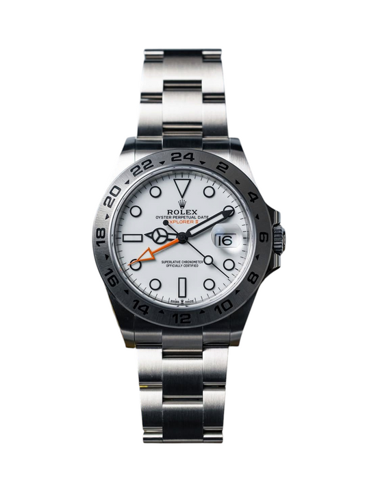 ACCHA TIME Explorer II watch with a white dial, silver steel oyster bracelet, and orange GMT hand on a mountain backdrop